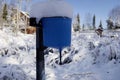 the blue washbasin on the street of a country house is covered with snow from above.