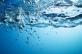 Blue water background adorned with bubbles and glistening water surface Royalty Free Stock Photo