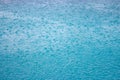 Blue water background with rain drops. Downpour drops on water surface. Ripple on pool surface. Blue shiny agua background. Royalty Free Stock Photo