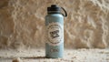 Blue water bottle with inspirational message on sandy surface Royalty Free Stock Photo