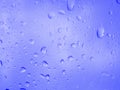 Blue water drops  on window glass of car, rain water background Royalty Free Stock Photo