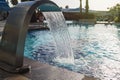 Blue water flowing into the pool. Filling outdoor swimming pool. Blurred background. Royalty Free Stock Photo