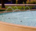Blue water fountain arcs in a park Royalty Free Stock Photo