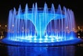 blue water fountain with LED lights at night generative AI Royalty Free Stock Photo