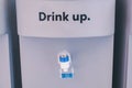 Blue water gallon with word `It`s free,Drink up,Stress?`on electric water cooler