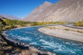 Blue water of Gilgit river flowing through Gupis. Royalty Free Stock Photo