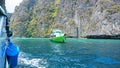 Blue water, green hills and steep rocks. The boat sails near the island. Boat with tourists in the Bay