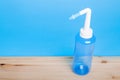 Blue water pulse nasal wash bottle on blue background, nasal irrigation concept