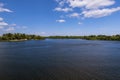 Blue water in the river. The forest is green. Sky is blue. White lush clouds. Summer landscape Royalty Free Stock Photo