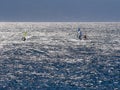 Blue water three windsurfers briiliant sun