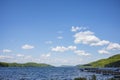 The blue waters of Otsego Lake in Cooperstown, New York, on a sunny summer day with cumulus clouds in the sky, photographed near a Royalty Free Stock Photo
