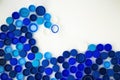 Blue wave from plastic bottle caps on a white background. Concept showing plastic pollution of the ocean. Sorting