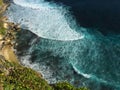 Blue wave of rip curl from the ocean splashes on yellow sand beach. Tropical sea danger. Royalty Free Stock Photo