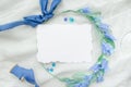 Blue wedding invitation mockup decorated with silk ribbon, crystals and bride wreath