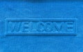 Blue welcome doormat closeup