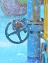 Blue wheel valve with pipe and wather flooding around Royalty Free Stock Photo