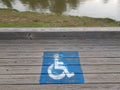 blue wheelchair logos on wood boardwalk near river