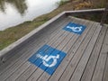 blue wheelchair logos on wood boardwalk near river