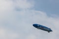 Blue and white airship in the sky with "Next Generation Mobility" advertisement on it Royalty Free Stock Photo