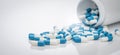 Blue-white antibiotic capsule pills spread out of plastic drug bottles. Antibiotic drug resistance. Prescription drugs. Healthcare Royalty Free Stock Photo