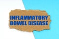 On a blue and white background lies a piece of cardboard with the inscription - Inflammatory Bowel Disease