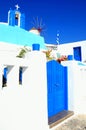 Blue and white bell tower and windmill in Oia village, Santorini