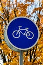 Blue and white bicycle lane sign indicating bike route, large round roadside traffic signage. Royalty Free Stock Photo