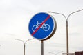 Blue and white bicycle lane sign with red forbid line indicating the end of the bike route, large round roadside traffic signage. Royalty Free Stock Photo