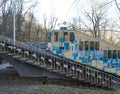 A blue and white cable funicular rises on rails along the slope. Funicular tram, side view. Station Kyiv, Ukraine