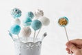 Blue and white cake pops with hand.