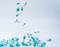 Blue-white capsule pill fall down to white table. Antibiotic drug use with reasonable. Antibiotic drug resistance problem