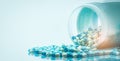 Blue and white capsules pill spilled out from white plastic bottle container. Global healthcare concept. Antibiotics drug Royalty Free Stock Photo