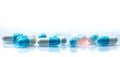 Blue and white capsules pill spread on white background with shadow and copy space. Global healthcare concept. Antibiotics drug