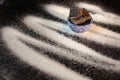 Ceramic bowl filled with baking chocolate chunks white sugar spilled in a zigzag pattered