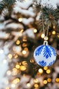 Blue white christmas ball on fir tree branch close up golden yellow light bokeh Royalty Free Stock Photo