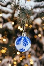 Blue white christmas ball on fir tree branch close up golden yellow light bokeh Royalty Free Stock Photo