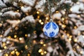 Blue white christmas ball on fir tree branch close up golden yellow light bokeh Royalty Free Stock Photo