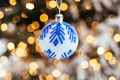 Blue white christmas ball on fir tree branch close up golden yellow light bokeh Royalty Free Stock Photo