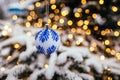 Blue white christmas ball on fir tree branch close up golden yellow light bokeh Royalty Free Stock Photo