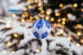 Blue white christmas ball on fir tree branch close up golden yellow light bokeh Royalty Free Stock Photo