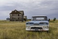 A blue and white classic pick up truck and abandoned home in ghost town of Robsart, SK Royalty Free Stock Photo