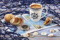 Blue and white coffee cup in nautical style, large sea shells, compass, blue fishing net.