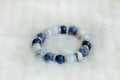 Blue and white color tone lucky fortune stone bracelet include which Lapis lazuli, Sodalite, Howlite and Moonstone on white wool b Royalty Free Stock Photo