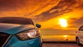 Blue and white compact SUV car with sport and modern design parked on concrete road by the sea at sunset. Environmentally friendly Royalty Free Stock Photo