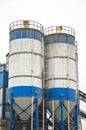 Blue and white concrete factory against white sky. Royalty Free Stock Photo