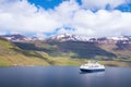 Blue and white cruising ship in a fjord of Seydisfjordur, Iceland, on a partly cloudy day Royalty Free Stock Photo