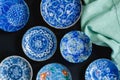 Blue and white decorative Japanese ceramic plates on black background - overhead photo