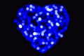 Blue and white defocused bokeh circles of light in the shape of a heart on a black backdrop Royalty Free Stock Photo