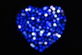 Blue and white defocused bokeh circles of light in the shape of a heart on a black backdrop Royalty Free Stock Photo