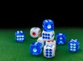 Blue and white dices on the green velvet surface Royalty Free Stock Photo